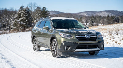 A car rental SUV drives down a snow-covered forest road in the Pennsylvania mountains