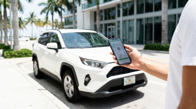 A stylish car rental parked on a sunny Miami street with colorful Art Deco buildings and palm trees