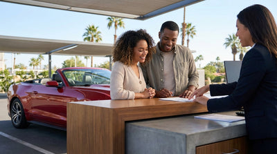 Couple in a convertible car rental driving along the scenic coast of California