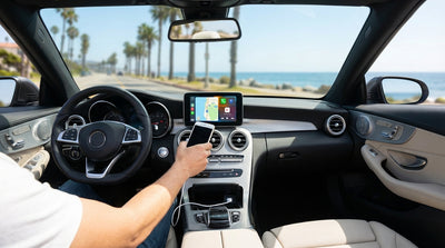 A person's hands plugging a USB cable into the dashboard of a car rental in California