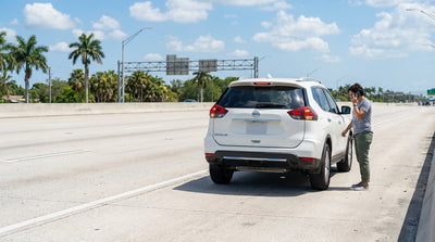A car rental pulled over on the hard shoulder of a sunny, multi-lane toll road in Florida