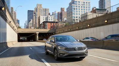 View from a car rental driving towards a tunnel entrance on a busy highway in New York City