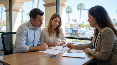 A silver car rental driving along the sunny California coast with blue ocean views