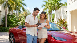 White convertible car rental parked near a sunny beach and tall palm trees in Miami