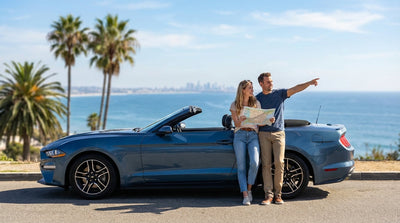A driver's view from their car hire on a sunny Los Angeles freeway with palm trees lining the road