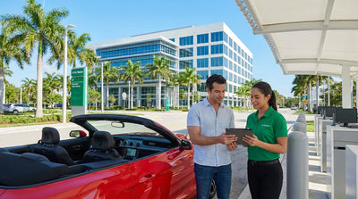 A modern car rental driving across a bridge toward the downtown Miami skyline under a clear blue sky