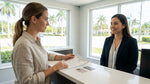 Customer handing identification documents to an agent at a Florida car rental desk