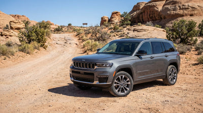 A red SUV car hire from Las Vegas parked on a desert road facing scenic red rock mountains under a clear blue sky