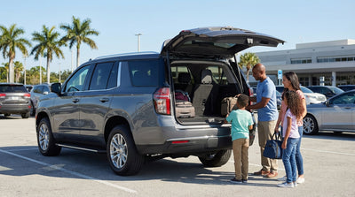 A large white SUV from a Florida car hire parked under sunny palm trees with the trunk open for luggage