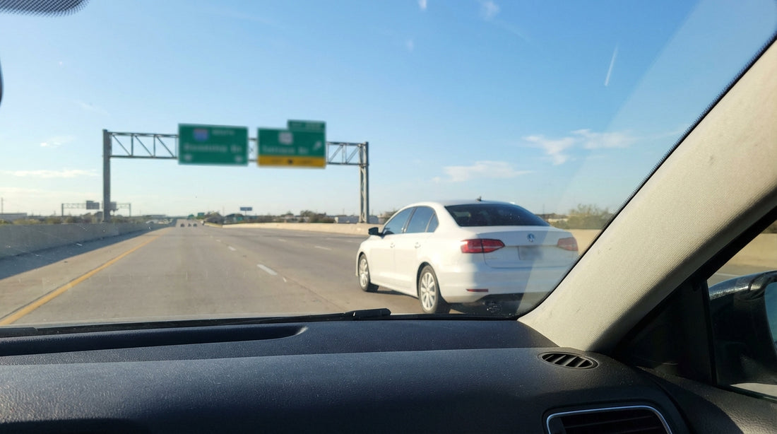 A car hire drives on a multi-lane Texas highway with other cars passing in the left lane