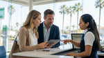 A person looking concerned while reviewing a car hire agreement at a rental counter in California