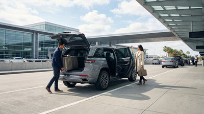 A car hire waiting for a passenger at the busy arrivals curb of the San Francisco airport terminal