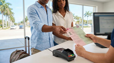 A convertible car hire driving on a scenic highway lined with palm trees in sunny Florida