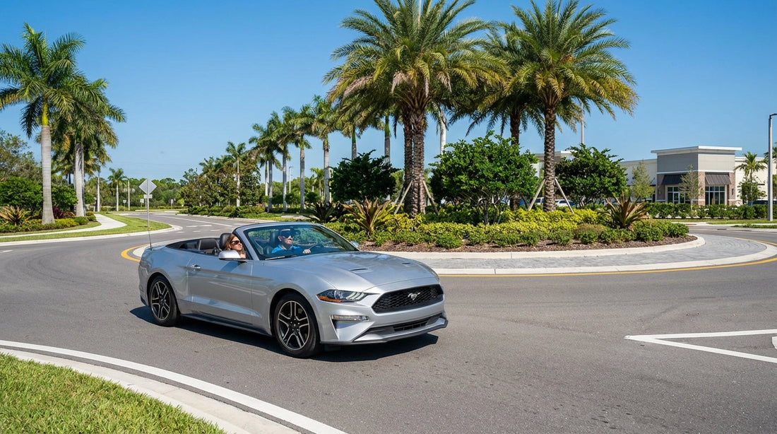 A car rental drives through a sunny, multi-lane roundabout with palm trees in Florida