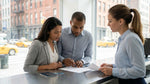 A customer carefully reviews a car rental agreement form at an office desk in New York