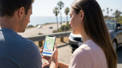 A car rental driving on a scenic, winding coastal highway during a sunny day in California