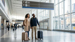 Passengers with luggage boarding a car rental shuttle bus outside JFK Terminal 8 in New York