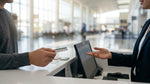 Person handing a credit card to an agent at a car hire desk in Los Angeles