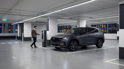 A car rental sits alone in a dimly lit, multi-level New York parking garage with concrete pillars
