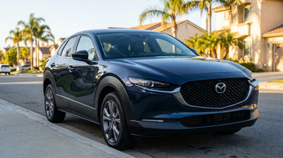 A large crack across the windscreen of a car rental parked on a sunny street in California