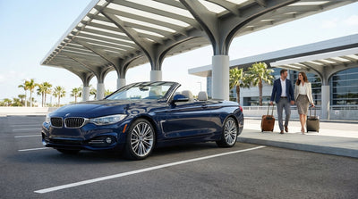 A row of luxury cars at a sunny United States airport car rental pickup area