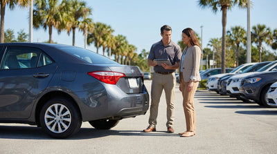A shiny red convertible car rental parked along a coastal highway with palm trees in Florida