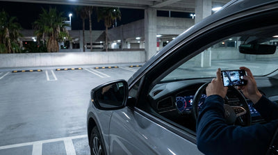 A lone vehicle in the brightly lit car hire return garage at Miami International Airport at night