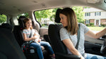 A young child smiles from a booster seat in a car rental driving through the scenic Pennsylvania countryside