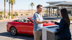 Close-up of a customer handing a credit card to an agent at a Las Vegas car rental counter