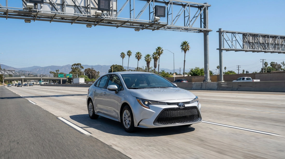 A car rental drives on a busy Los Angeles freeway with traffic and the downtown skyline in the distance