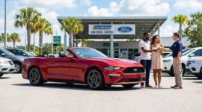 A red convertible Ford Mustang car rental parked under palm trees on a sunny day in Orlando