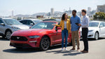 A red convertible car hire parked at a viewpoint overlooking the Golden Gate Bridge in San Francisco