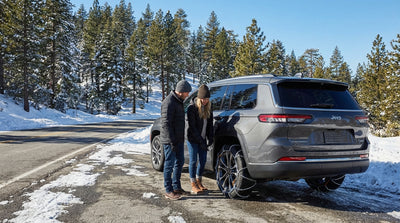 A California car hire drives along a scenic, snow-covered mountain road in the Sierra Nevada