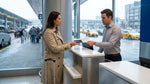Customer handing paperwork to an agent at a New York car rental desk