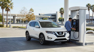 A car rental driving on a highway in Queens, New York, with a road sign directing traffic to JFK Airport
