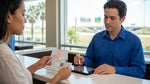 A person presenting a passport and driver's licence at a car rental desk in Texas