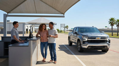 Person holding keys next to a modern car rental parked on a Texas desert road