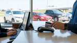 Man handing a corporate credit card to an agent at a car hire counter in Texas