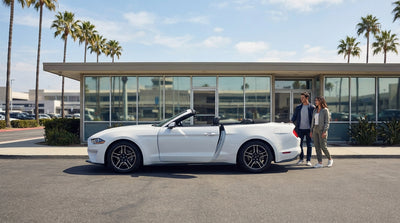 A red convertible car hire driving along the scenic Pacific Coast Highway in California