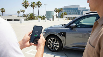 A white electric car hire plugged into a charging station under sunny California skies with palm trees