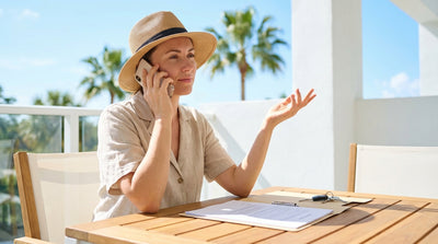 A white convertible car rental driving down a palm-tree-lined road on a sunny day in Florida
