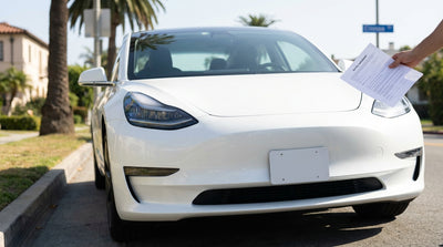 Front view of a modern car hire parked on a sunny street lined with palm trees in California