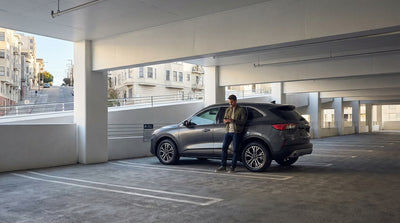 A sleek car rental parked on the top floor of a San Francisco parking garage at dusk
