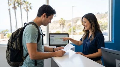 A convertible car hire driving along a sunny, winding coastal road in California