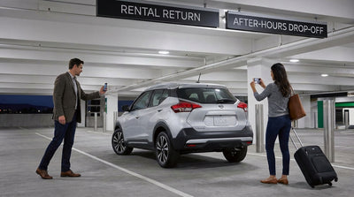 A silver car hire vehicle parked alone in a concrete Pennsylvania airport parking lot at night