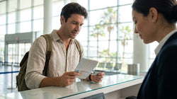 Person handing an ID card to an agent at a car rental desk in Florida