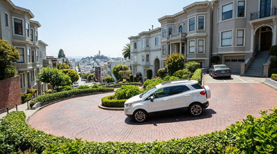A red car hire winds down the famously crooked Lombard Street in sunny San Francisco