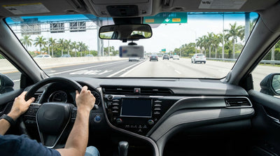 A car rental drives on the I-95 highway in Miami, approaching the bright orange express lane markers