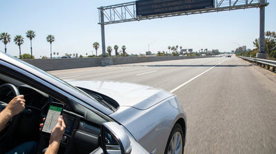 A driver's view from a car rental on a busy Los Angeles freeway with the city skyline ahead