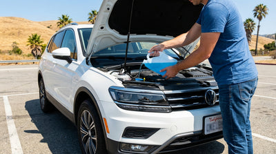 A person checks under the hood of their car hire vehicle parked along a sunny road in California